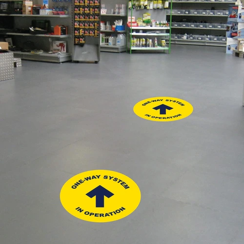 Floor sticker with directional arrow in a retail store.